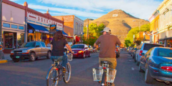 Two bikers riding on the street in Downtown Salida