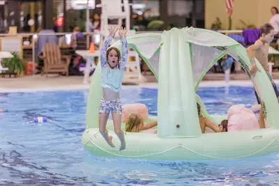 Girl jumping off large inflatable island