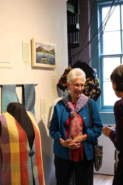 Fiber Arts Gathering , Woman gathered around art work